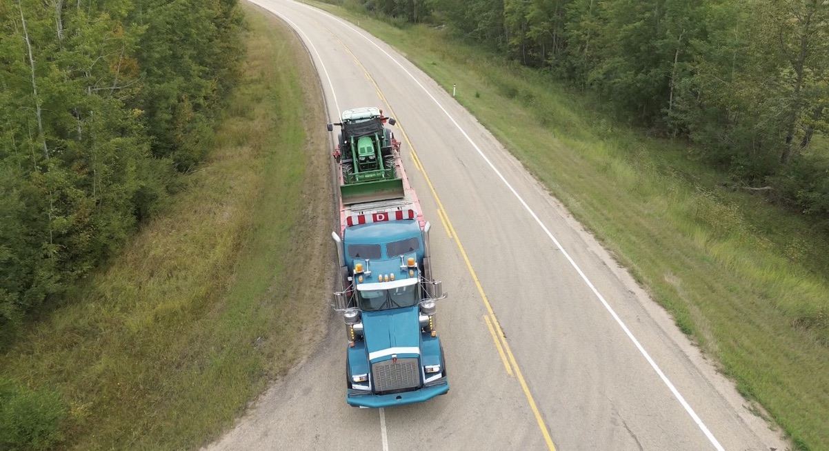 Aerial view of equipment transport on a gravel road