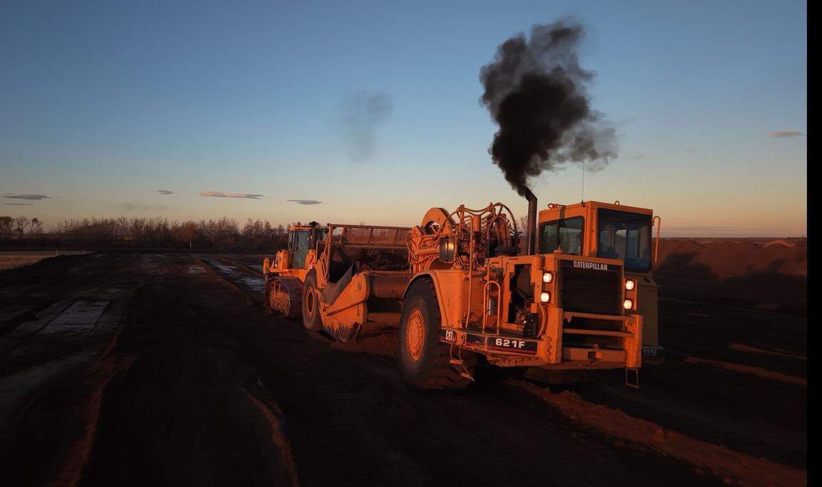 Cat scraper working at sunset — RTRC fleet