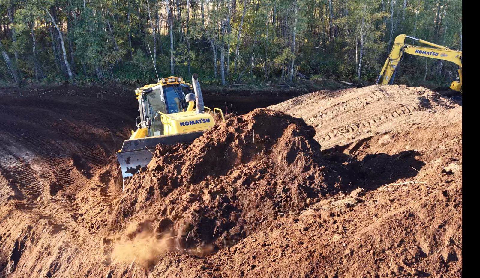 Dozer and excavator working together on lease construction