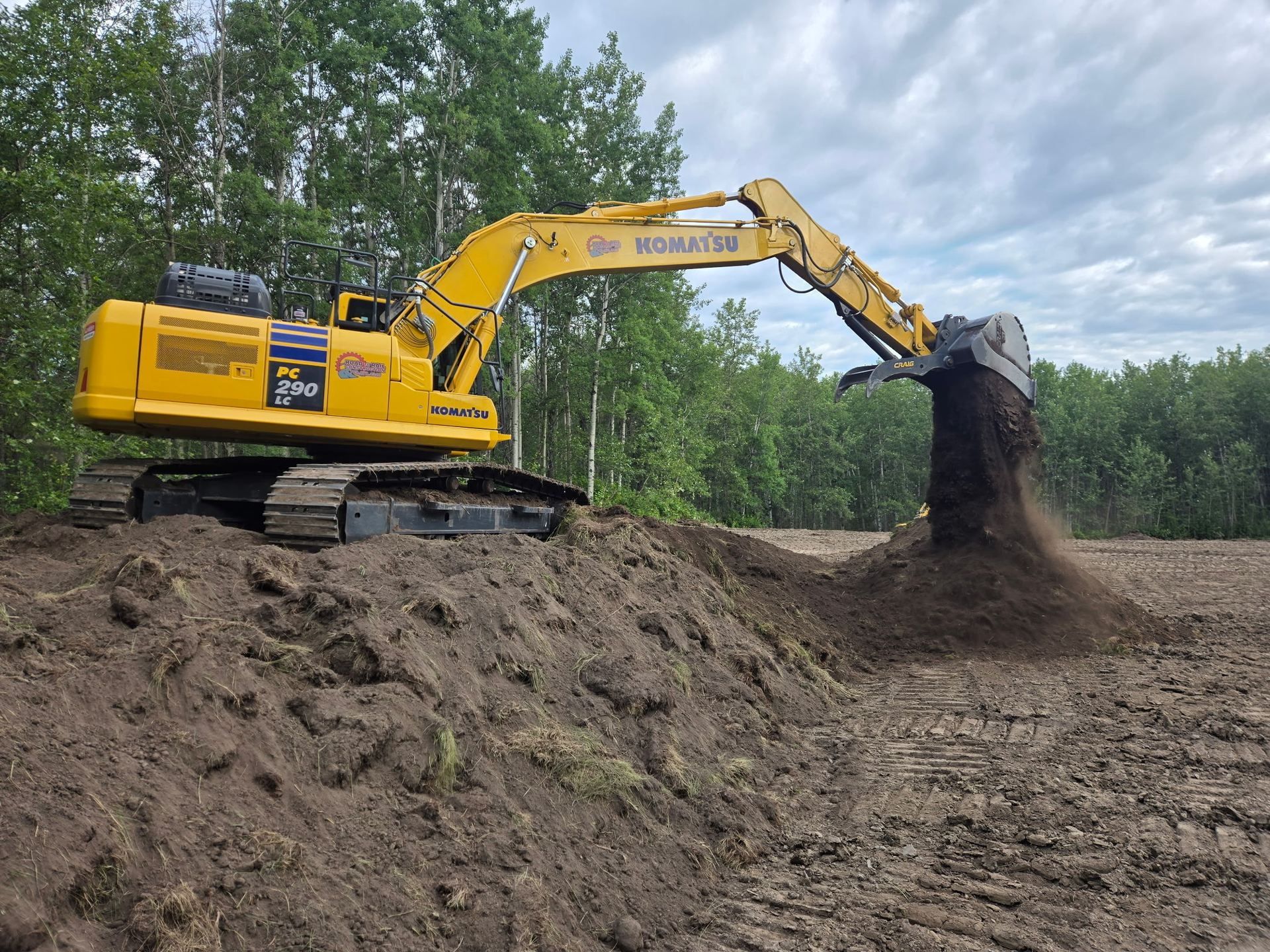 Excavator constructing an oilfield lease pad